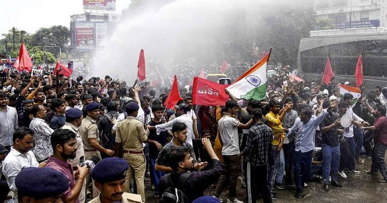 Bihar Police use tear gas shells and lathi charges against students who are protesting and calling for Pradhan's resignation.